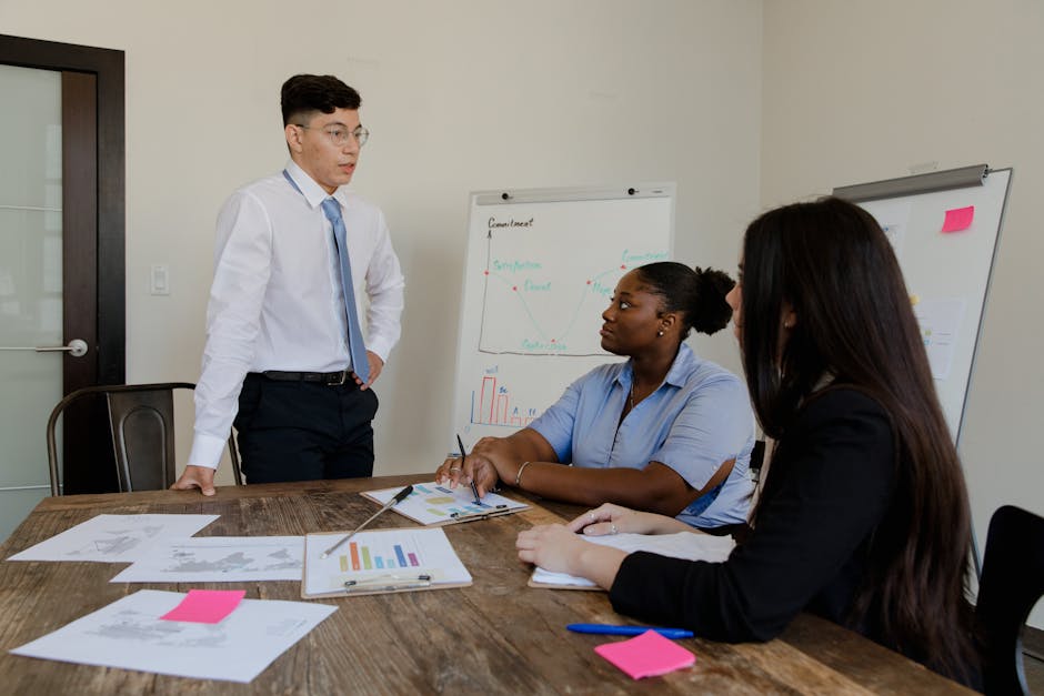 A diverse group of professionals engaged in a meeting around a boardroom table.